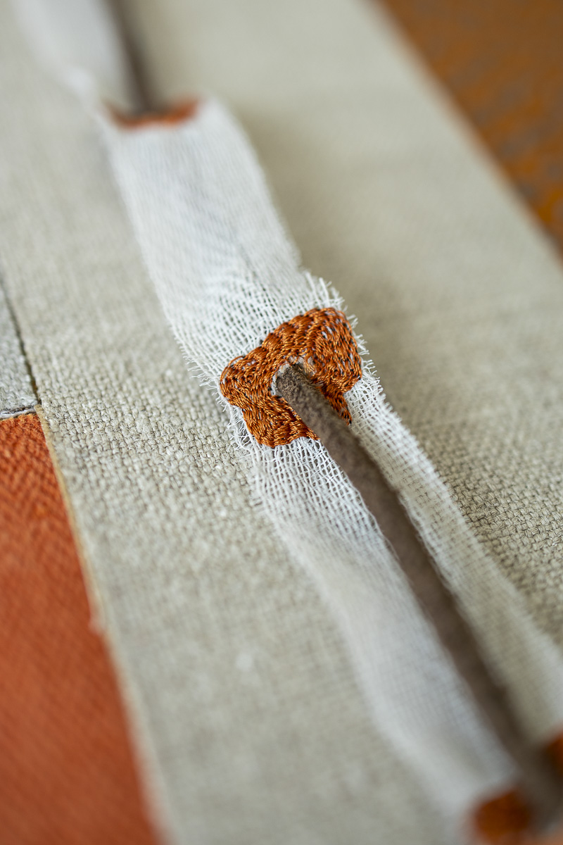 Close-up of stitched geometric pattern in upcycled textile wall panel