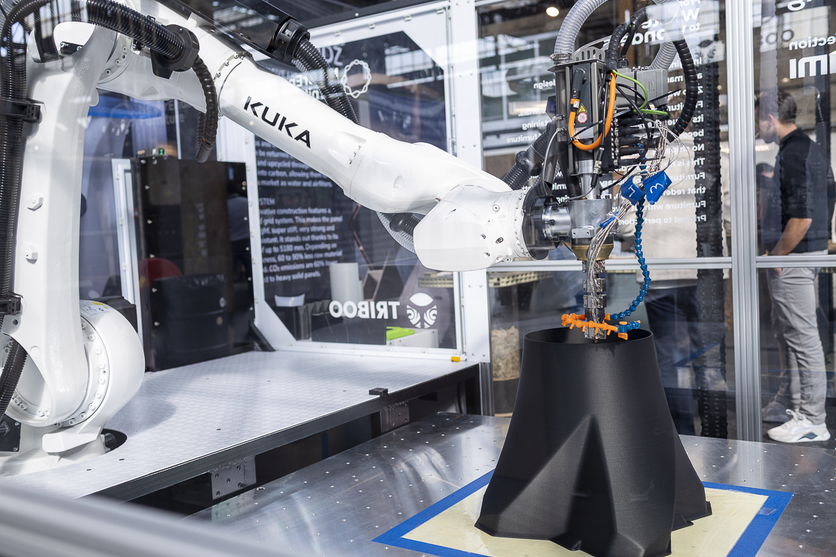 Industrial robotic arm producing a material prototype at the MaterialDistrict fair, showcasing innovations for materials in office design.