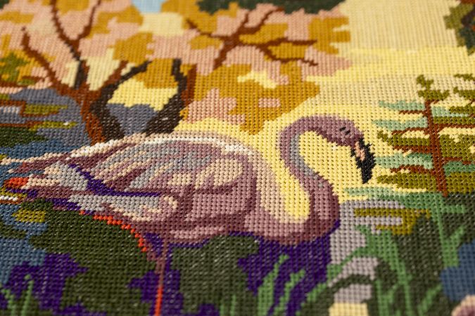 Textiel wandpaneel met hersteld borduurwerk, omlijst met handgesneden nepleren elementen