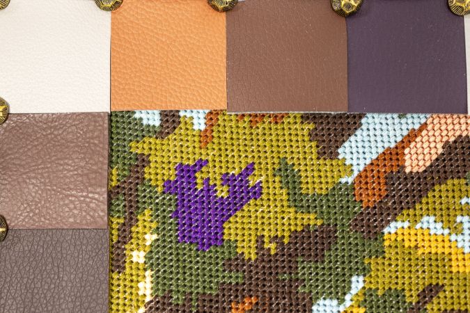 Embroidered textile artwork upcycled into a contemporary wall panel with pixelated edge