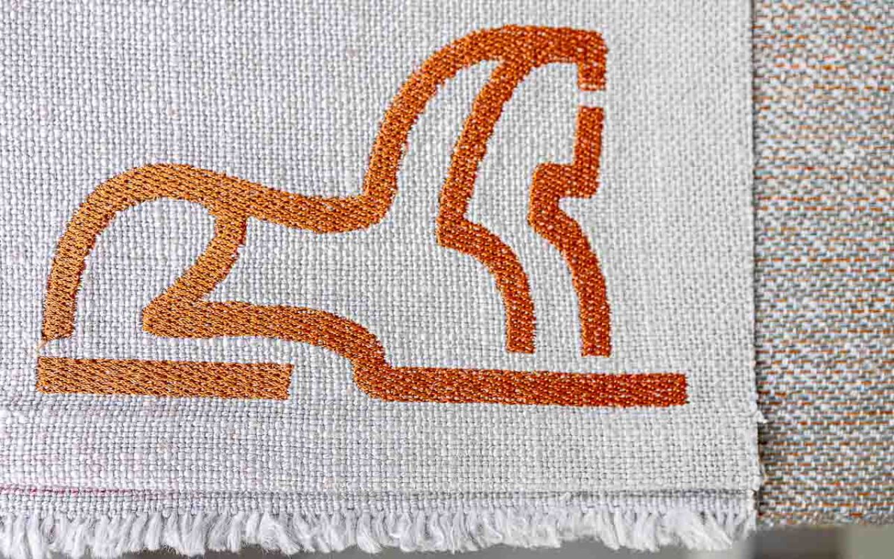 Custom logo embroideries on sustainable wall art and other opbjects